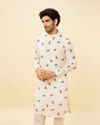 alt message - Manyavar Men Cream Angrakha Style Peacock Feather Printed Kurta Set image number 0