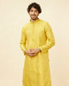 alt message - Manyavar Men Illuminating Yellow Bel Buti Patterned Kurta Set image number 0