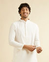 alt message - Manyavar Men Warm White Self Textured Kurta Set with Embroidered Neckline image number 0